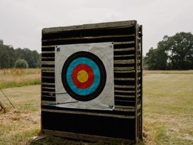 An archery target on a wooden backing in an open area at Hurricane Lodge Fair Oak