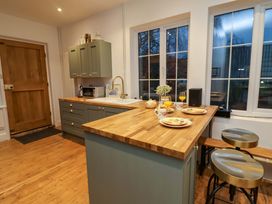 A kitchen with a wooden island and utensils at The White House in Norwich