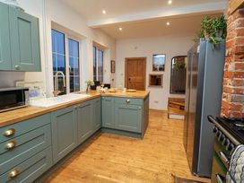 A kitchen with cabinets, a sink, and a refrigerator at The White House in Norwich