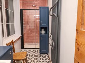 A bathroom with a shower and storage cabinet at The White House in Norwich
