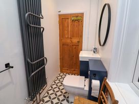 A bathroom with a toilet, sink, and mirror at The White House in Norwich