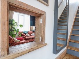 A hallway with a window, staircase, and a plant at The White House in Bracondale