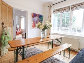 A dining room with a table and flowers at The White House in Bracondale