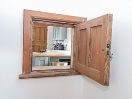 A window opening to a kitchen with counter and appliances at The White House in Bracondale