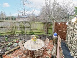 A garden with a wooden table and chairs at The White House in Bracondale