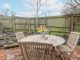 A garden with a wooden table and chairs and flowers at The White House in Bracondale