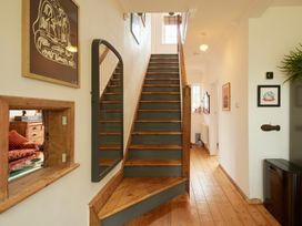 A staircase with wall art and a mirror in a hallway at The White House, Riverside Retreat in Bracondale