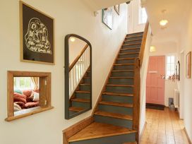 A hallway with a staircase and art on the wall at The White House, Riverside Retreat Bracondale