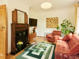 A living room with a coffee table, tv, and sofa at The White House, Riverside Retreat in Bracondale