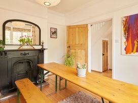A dining room with a table, benches, and a fireplace at The White House, Riverside Retreat, Bracondale