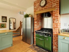 A kitchen with a green stove and stainless steel refrigerator at The White House, Riverside Retreat Bracondale
