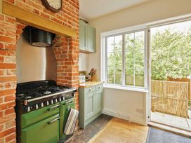 A kitchen with a green stove and window at The White House, Riverside Retreat in Bracondale