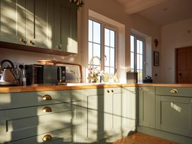 A kitchen with cabinets, a sink, and a microwave at The White House, Riverside Retreat Bracondale