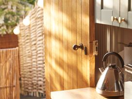 A kitchen with a kettle on the counter and a wooden door at The White House, Riverside Retreat Bracondale