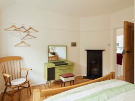 A bedroom with a bed, dresser, mirror, and fireplace at The White House, Riverside Retreat Bracondale