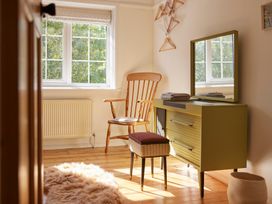 A bedroom with a rocking chair and dresser at The White House, Riverside Retreat in Bracondale