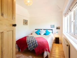 A bedroom with a bed and paintings on the wall at The White House, Riverside Retreat Bracondale