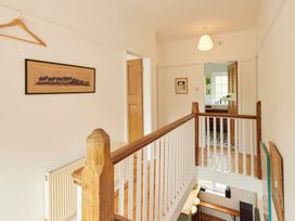 A hallway with a staircase and wall art at The White House, Riverside Retreat Bracondale
