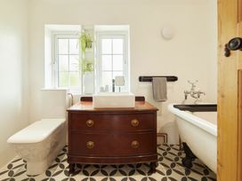 A bathroom with a wash basin and a bath tub at The White House, Riverside Retreat, Bracondale