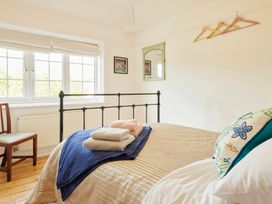 A bedroom with a bed and chair at The White House, Riverside Retreat in Bracondale