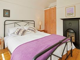 A bedroom with a bed and a bedside table at The White House, Riverside Retreat in Bracondale