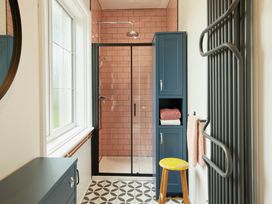 A bathroom with a shower stall and towel storage at The White House, Riverside Retreat, Bracondale