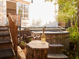 A hot tub with glasses and a bottle on a table at The White House, Riverside Retreat, Bracondale