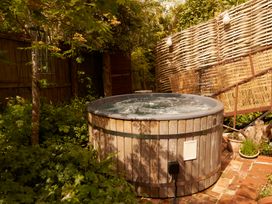 A hot tub surrounded by plants in a garden at The White House, Riverside Retreat in Bracondale