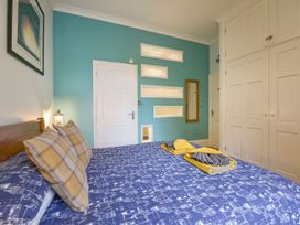 A bedroom with a bed and wardrobe at The Old Signal House in Torpoint