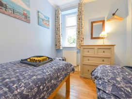 A bedroom with two beds and a chest of drawers at The Old Signal House in Torpoint