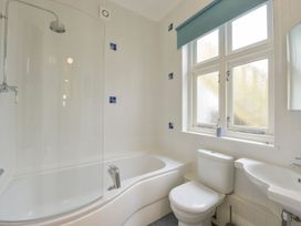 A bathroom with a bathtub, shower, toilet, and sink at The Old Signal House in Torpoint