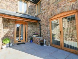An outdoor entrance with wooden doors and stone walls at Grange Cottage Crediton