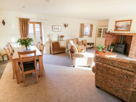 A living room with dining area and fireplace at Grange Cottage in Crediton