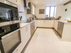 A kitchen with appliances and cabinets at Grange Cottage in Crediton