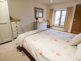 A bedroom with a bed and furniture at Grange Cottage in Crediton