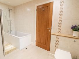 A bathroom with a bathtub and shower at Grange Cottage in Crediton