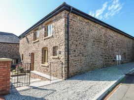 A stone building with windows and a door at Grange Cottage in Crediton