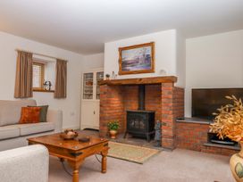 A living room with a fireplace and sofa at Grange Cottage in Coldridge