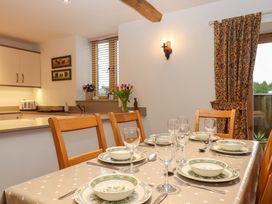 A dining room with a table set for a meal at Grange Cottage in Coldridge