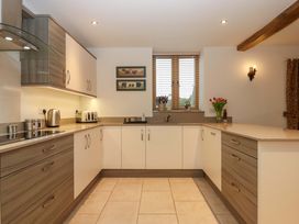 A kitchen with cabinets, counter, sink and kettle at Grange Cottage in Coldridge