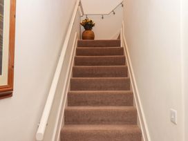 A staircase with a vase and flowers at Grange Cottage Coldridge