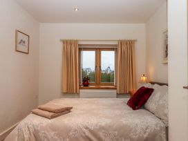 A bedroom with a bed and window at Grange Cottage Coldridge