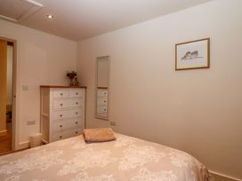 A bedroom with a bed and a dresser at Grange Cottage Coldridge