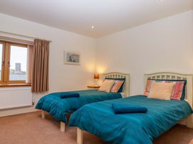 A bedroom with twin beds and a window at Grange Cottage Coldridge