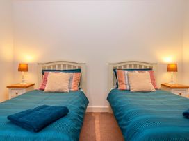 A bedroom with two single beds and lamps at Grange Cottage in Coldridge