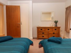 A bedroom with two beds and a wooden dresser at Grange Cottage in Coldridge