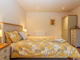 A bedroom with a bed and wardrobe at Grange Cottage in Coldridge