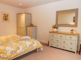 A bedroom with a bed and storage furniture at Grange Cottage in Coldridge