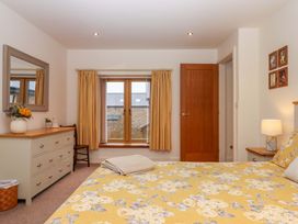 A bedroom with a bed and dresser at Grange Cottage Coldridge