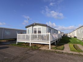 A mobile home with a deck and grass area at CG 55